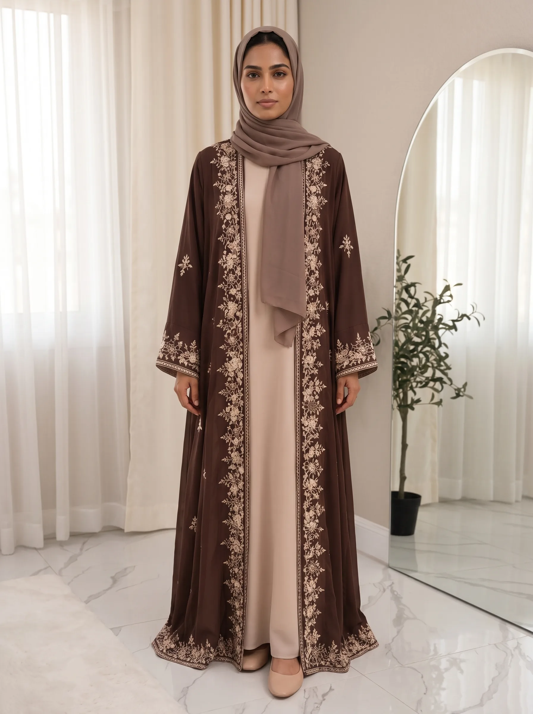 Model wearing a brown open abaya with ivory floral embroidery, worn over a cream inner dress — Front view